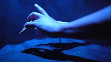 Close-up, Hands of a Magician Performing Tricks with a Deck of Cards. Blue Lighting. Conjurer Shows Focus. Camera Quickly Rotates 360 Degrees. video