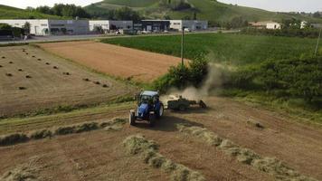 máquina tractora trabajando en fardos de heno en el campo agrícola video