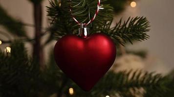 filmagem de natal em closeup de ornamento em forma de coração na árvore de natal video