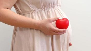 ootage of a pregnant woman holding heart .Health concept video