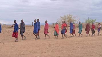 Footage of men and women of masai tribe welcoming tourists in their village with singing wearing traditional clothes. Village in amboseli national reserve,Kenya.August 27,2022 video
