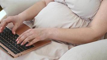 Pregnant woman uses laptop for work,online shopping,blog about pregnancy video