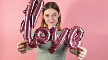 jong gelukkig vrouw Holding liefde ballon.st Valentijnsdag studio portret. video