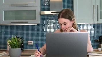 mujer joven aburrida que usa una computadora portátil para el trabajo o la educación en línea. video