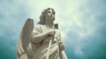 The statue of an Angel on time lapse blue clouds - Loop video