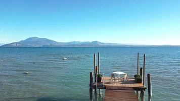 Tisch und Stühle am Pier des Gardasees in Italien video