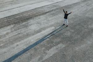 Conception of freedom. Top view of man that standing on the road at evening alone photo