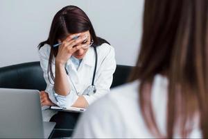 Young woman have a visit with female doctor in modern clinic photo