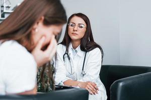 Girl have mental breakdown and crying. Young woman have a visit with female doctor in modern clinic photo