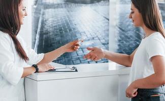 Doctor gives drugs to patient. Young woman have a visit with female doctor in modern clinic photo