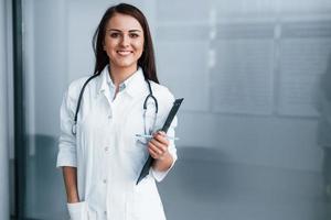 Friendly young nurse indoors in modern clinic ready to help you photo