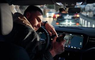 Dont drink and drive. Rear view of handsome unshaved man in fashionable clothes inside his automobile photo