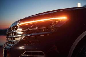 Close up particle view of of front part of modern new car parked outdoors photo