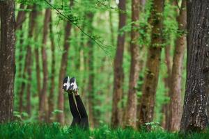 Legs of woman that have a rest and lying down on ground in forest photo