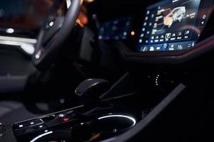 Steering wheel and navigation display. Close up view of front park of new modern black automobile photo