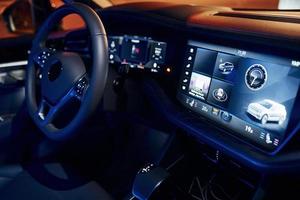 Steering wheel and navigation display. Close up view of front park of new modern black automobile photo