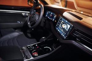 Steering wheel and navigation display. Close up view of front park of new modern black automobile photo