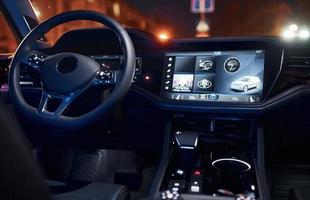 Steering wheel and navigation display. Close up view of front park of new modern black automobile photo