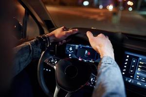 Handsome unshaved man in fashionable clothes riding his automobile photo
