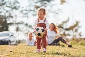 familia feliz jugando con una pelota de fútbol al aire libre cerca del bosque. con hija e hijo foto