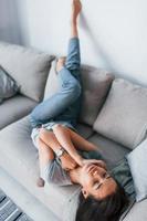 Young beautiful woman in casual clothes lying down at home alone photo