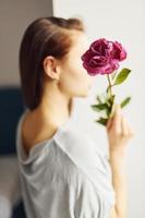 Holding flowers. Young woman resting and spending weekend at home alone at home photo