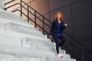 Young european redhead woman have walk on the stairs outdoors photo