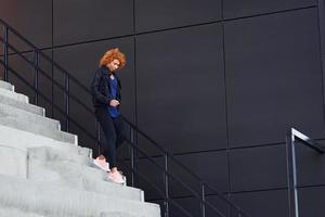 Young european redhead woman have walk on the stairs outdoors photo