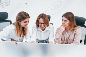 Front view of group of business women in formal clothes indoors in the office photo