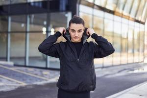 Portrait of young brunette in sportive clothes that have fitness day outdoors in the city photo