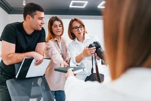 grupo de empresarios con ropa formal en el interior de la oficina mirando fotos en la cámara