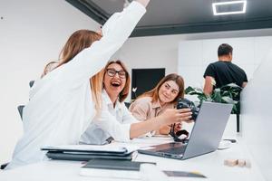 Front view of group of business people in formal clothes working indoors in the office photo