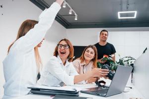 Front view of group of business people in formal clothes working indoors in the office photo