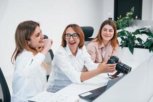 With professional camera. Group of business people in formal clothes indoors in the office photo