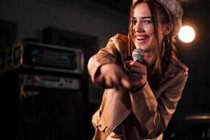 joven y bella intérprete femenina ensayando en un estudio de grabación foto