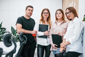 grupo de empresarios vestidos con ropa formal parados juntos en el interior de la oficina foto