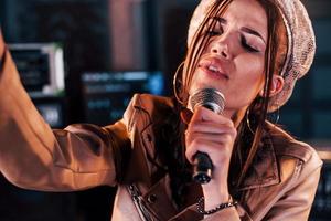 Young beautiful female performer rehearsing in a recording studio photo