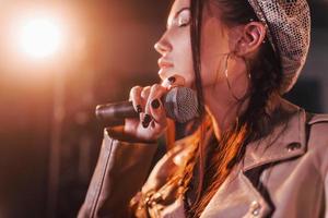 Young beautiful female performer rehearsing in a recording studio photo