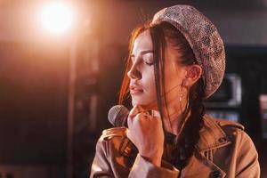 joven y bella intérprete femenina ensayando en un estudio de grabación foto