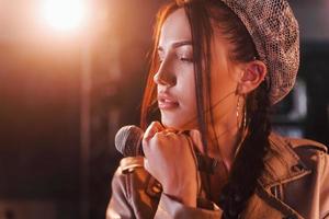 joven y bella intérprete femenina ensayando en un estudio de grabación foto