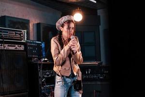 Young beautiful female performer rehearsing in a recording studio photo