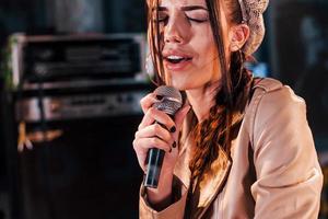 Young beautiful female performer rehearsing in a recording studio photo