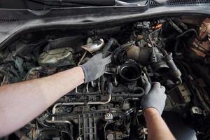 First person view of man's hands that repairs automobile. Conception of automobile service photo