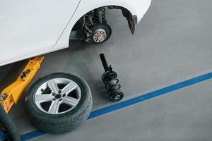 Car wheel lying down near automobile. Conception of repairment photo