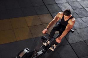 un hombre fuerte con ropa deportiva tiene un día de entrenamiento en el gimnasio foto