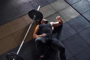 Taking a break. Strong african american man in sportive clothes have workout day in the gym photo