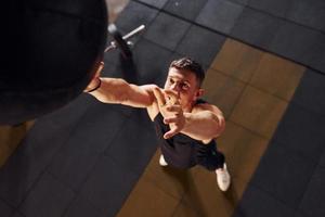 Strong man in sportive clothes playing basketball in the gym photo