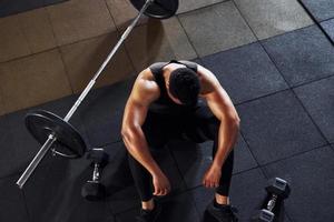 Taking a break. Strong african american man in sportive clothes have workout day in the gym photo