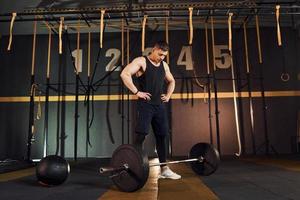 hombre fuerte con ropa deportiva levantando pesas en el gimnasio foto