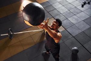 Playing basketball. Strong african american man in sportive clothes have workout day in the gym photo